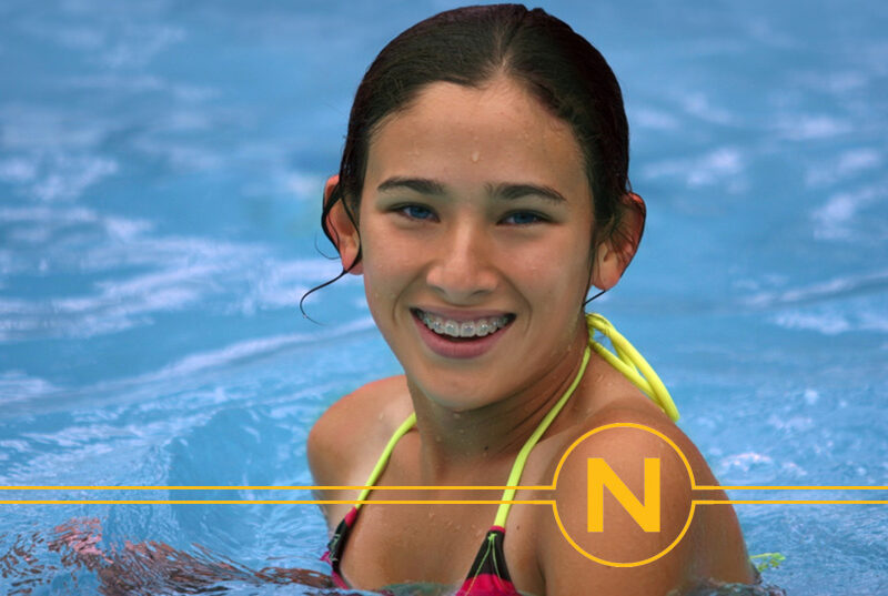 teen in pool smiling with braces