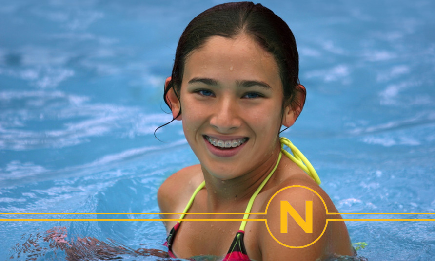 teen in pool smiling with braces